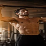 Man doing a controlled pull-up in a warm gym for a calisthenics and testosterone article