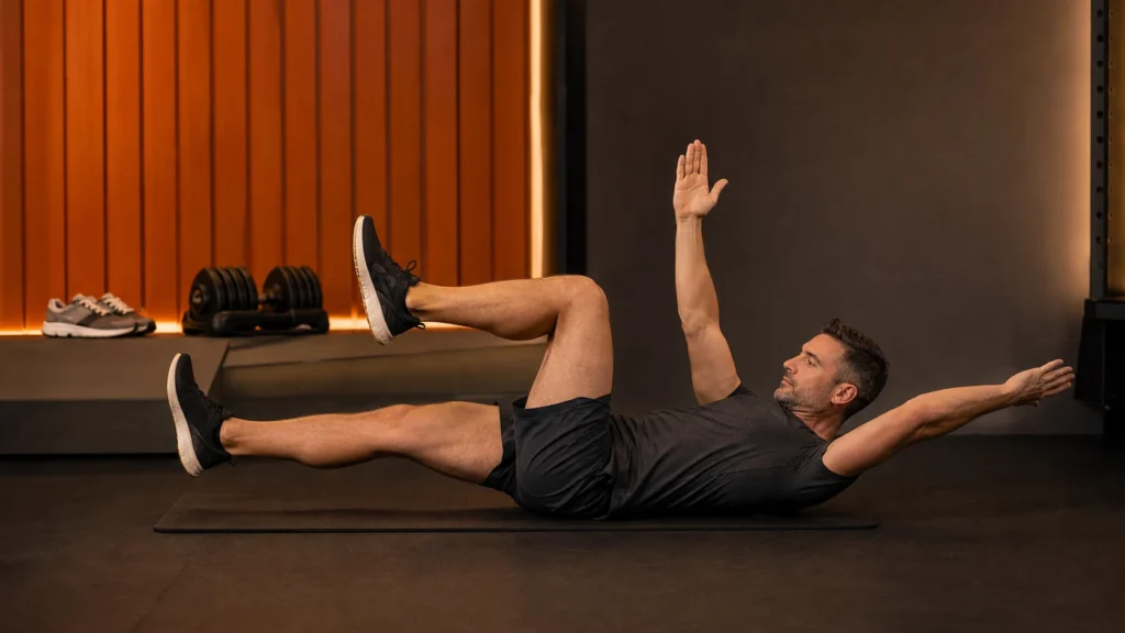 Man performing a controlled dead bug core exercise as part of a complete weight-loss training plan