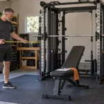 Illustrative scene of a man over 50 measuring space beside a generic integrated rack, Smith machine and cable system.